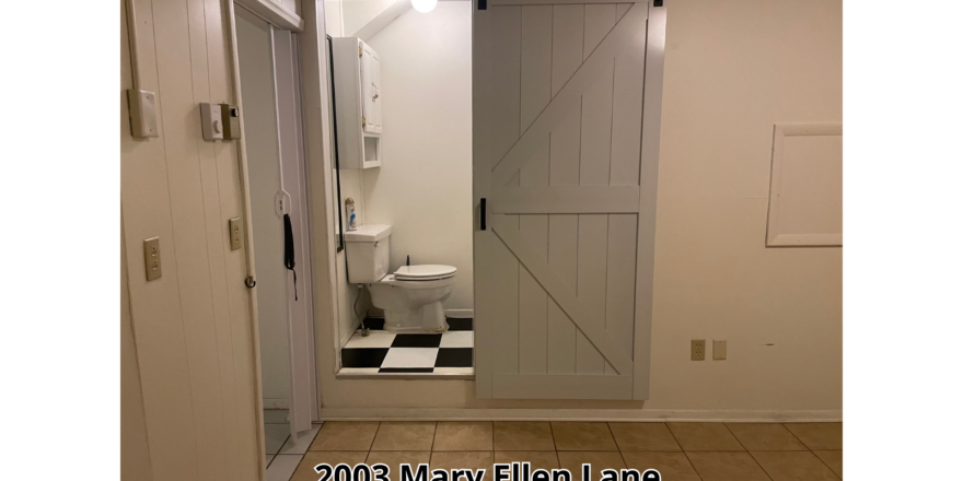 a white bathroom with a black and white checkered floor