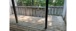 a porch with a wooden floor and railing