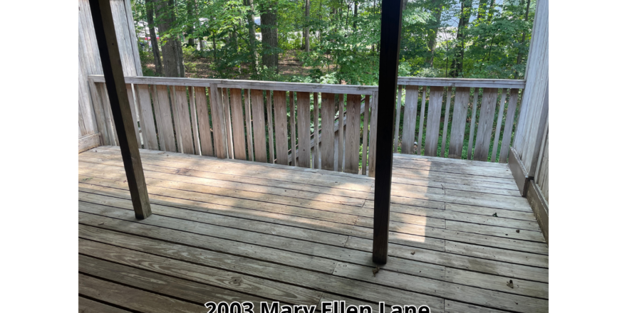 a porch with a wooden floor and railing