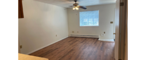 an empty room with a ceiling fan and hard wood floors