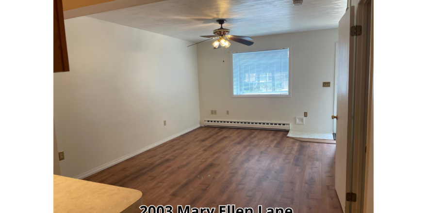 an empty room with a ceiling fan and hard wood floors