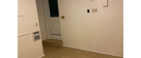 an empty room with a white door and tile floor