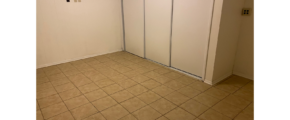 an empty room with a tile floor and white walls
