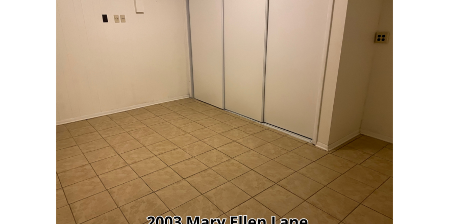 an empty room with a tile floor and white walls