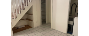 an empty room with a stair case and tiled floor
