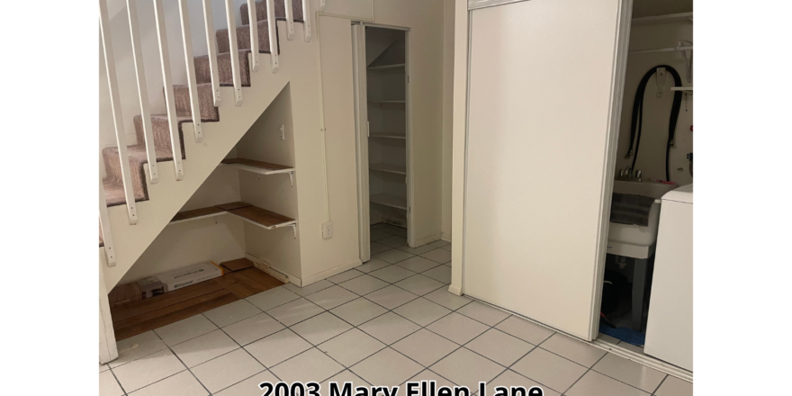 an empty room with a stair case and tiled floor