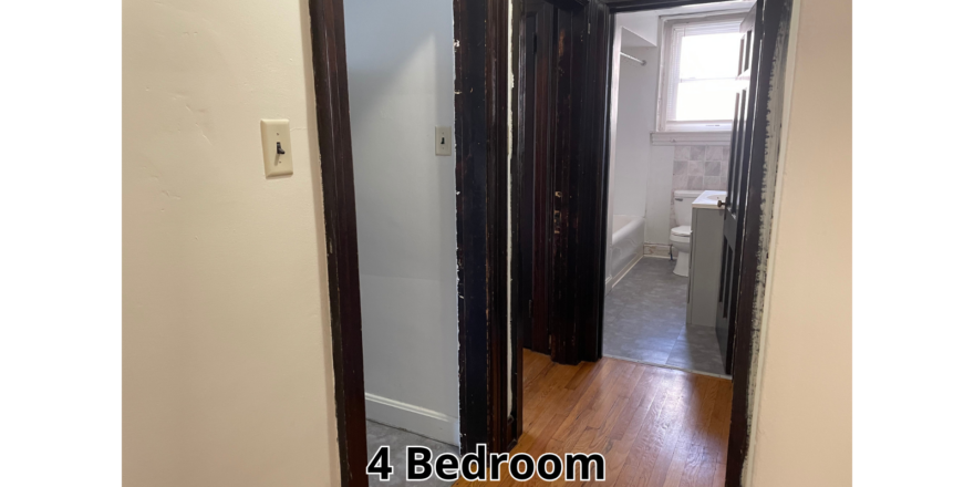 a hallway leading to a bathroom and a toilet