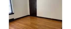 an empty room with wood floors and a door