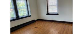 an empty room with three windows and a hard wood floor