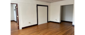 an empty room with wood floors and a ceiling fan