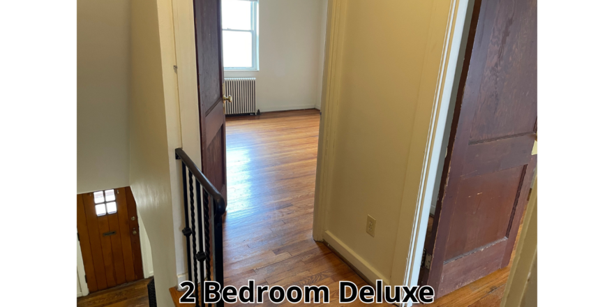 a hallway with a door and a wooden floor