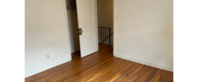 an empty room with a door and a wooden floor