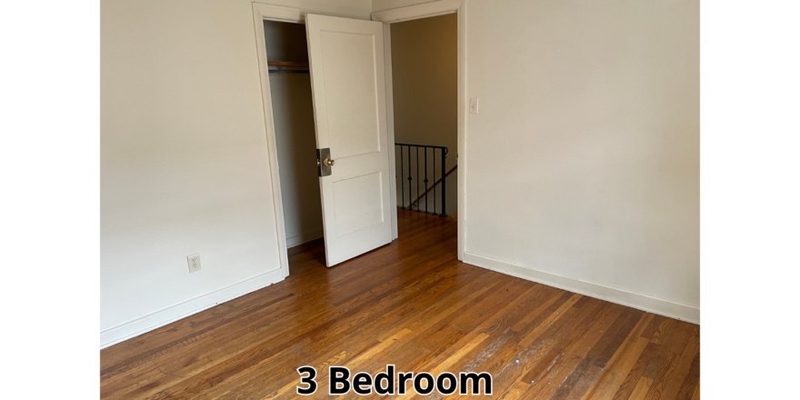 an empty room with a door and a wooden floor