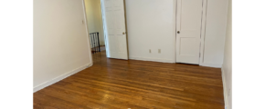an empty room with wood floors and white walls