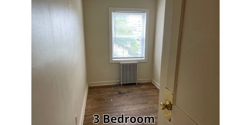an empty room with a radiator and a window