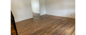 an empty room with wood floors and white walls