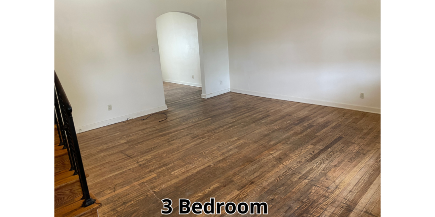 an empty room with wood floors and white walls