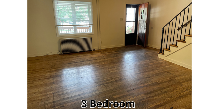 an empty living room with hard wood floors
