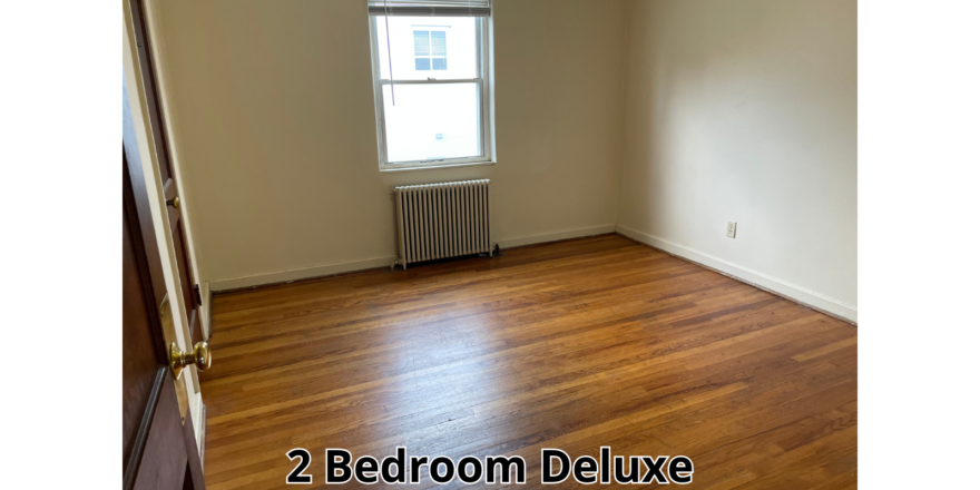 an empty room with wood floors and a radiator