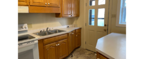a kitchen with wooden cabinets and a white stove top oven