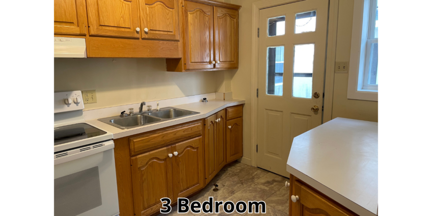 a kitchen with wooden cabinets and a white stove top oven