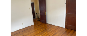 an empty room with two doors and a hard wood floor