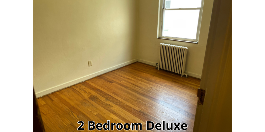 an empty room with wood floors and a radiator