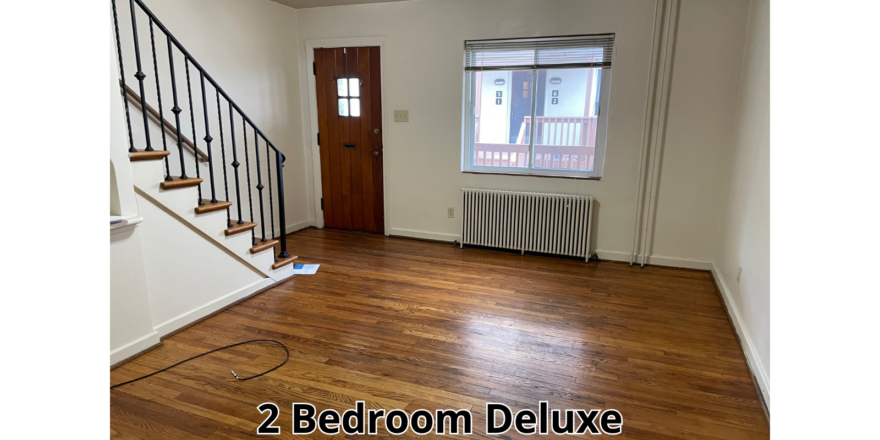an empty room with a wooden floor and stairs
