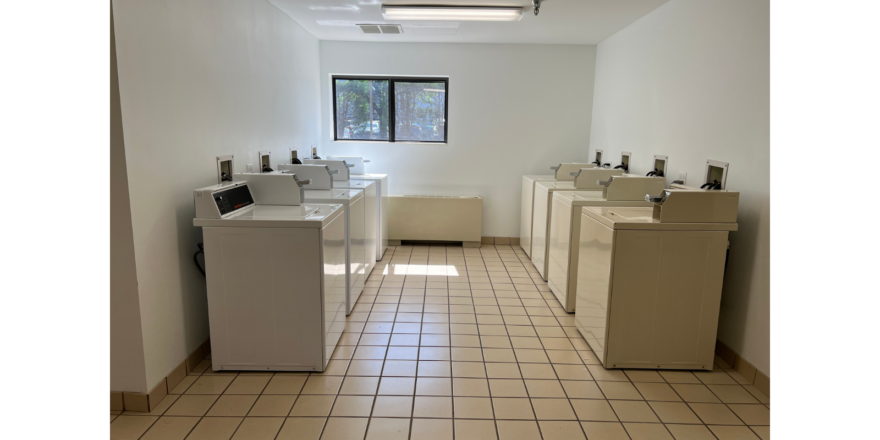 a row of sinks in a bathroom next to a window