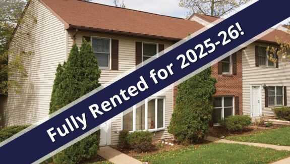 a blue and white ribbon is in front of a house