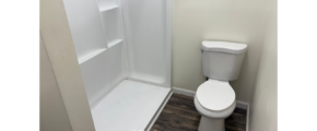 a white toilet sitting next to a walk in shower