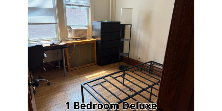 a bedroom with a bed, desk, and computer