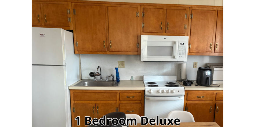 a kitchen with a table, refrigerator and microwave