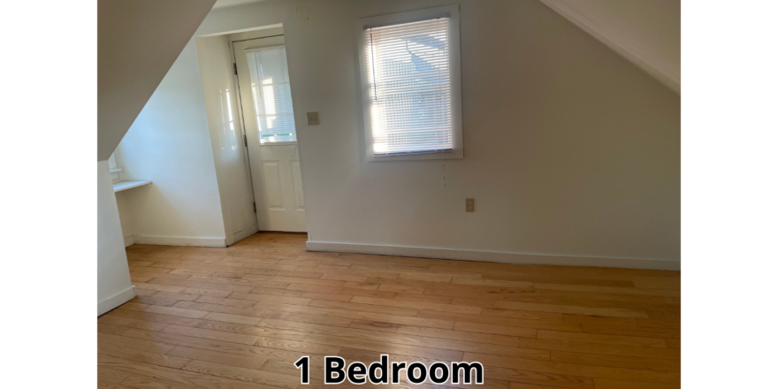 an empty room with a white door and window