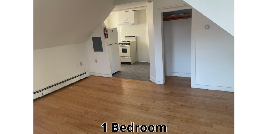 an empty room with wood floors and a white wall