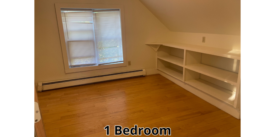 an empty room with a book shelf and a window