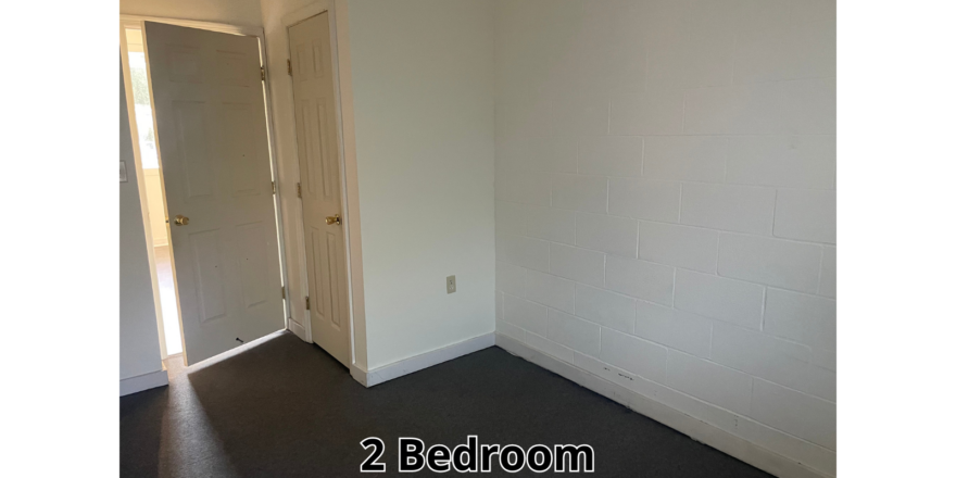 an empty room with a door and a mirror