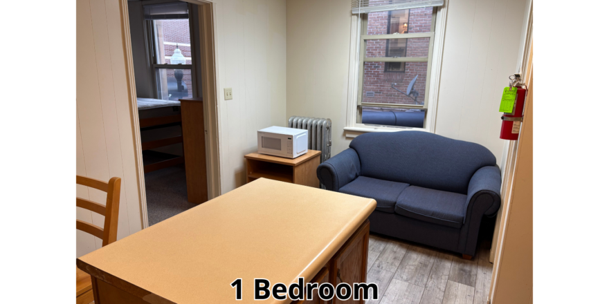 a living room with a couch a chair and a desk