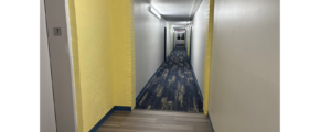 Hallway with carpet and light yellow walls