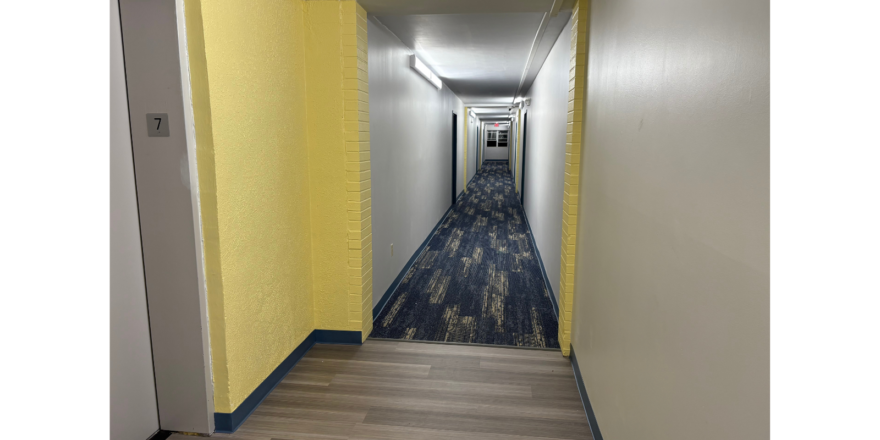 Hallway with carpet and light yellow walls