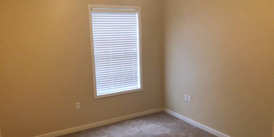 Unfurnished, carpeted bedroom with window