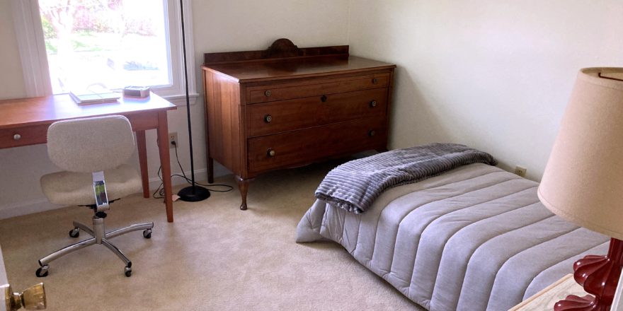 Bedroom with bed, dresser, desk, and chair