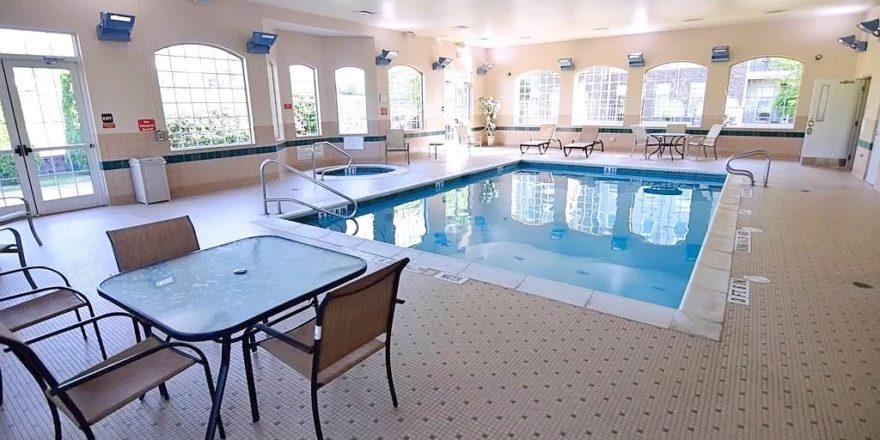 Pool area with lounge chairs and patio tables and seating