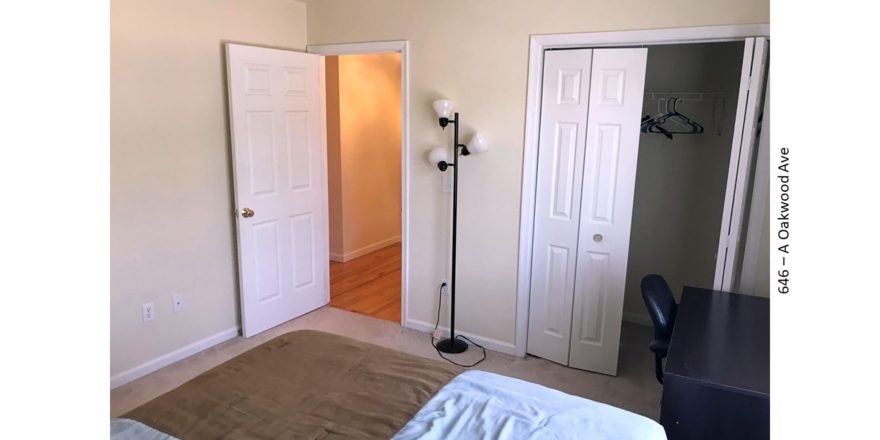 Bedroom with desk and chair, closet, and lamp