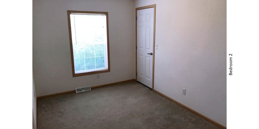 Unfurnished, carpeted bedroom with closet and a window