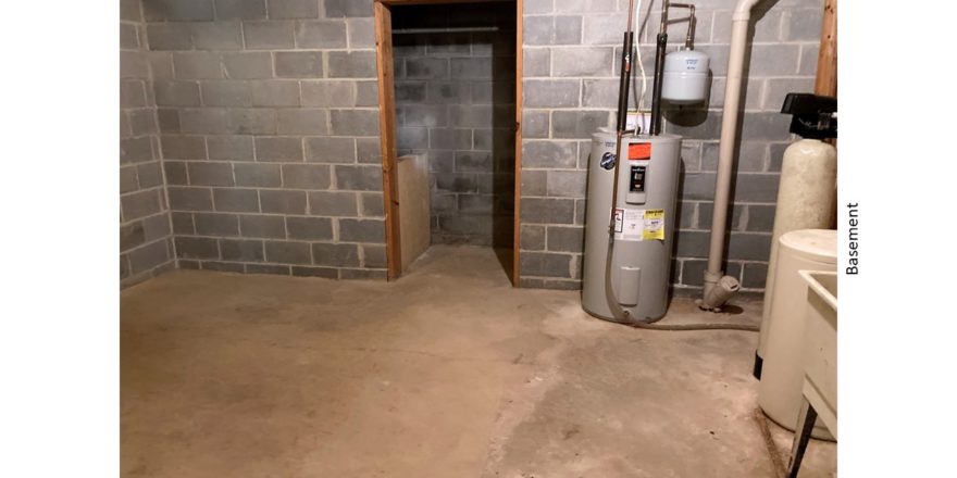 Unfinished basement with sink and water heater