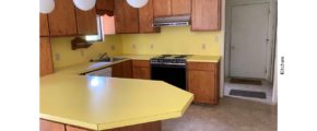 Kitchen with yellow countertops, wood-tone cabinets and appliances