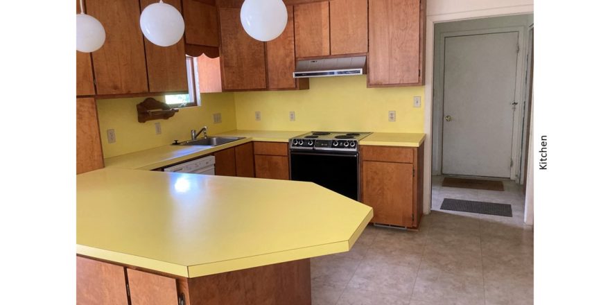 Kitchen with yellow countertops, wood-tone cabinets and appliances