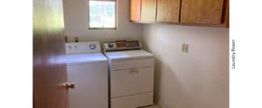 Laundry room with washer and dryer and wood-tone cabinets