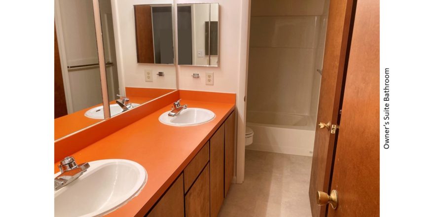 Bathroom with double vanity, toilet, and tub/shower combo